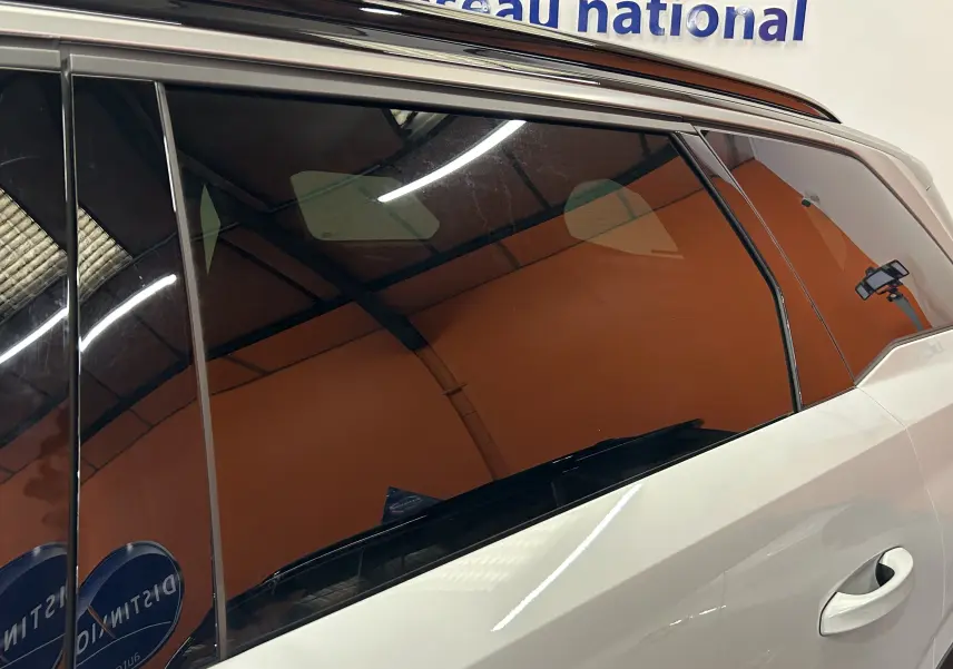 Vue latérale droite du Peugeot 5008 blanc, mettant en valeur les vitres teintées et la poignée de porte arrière.