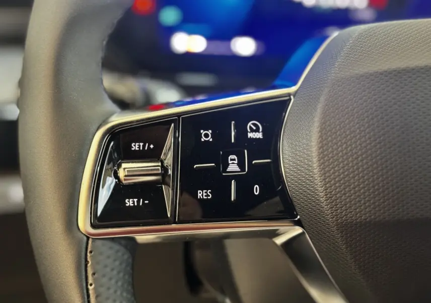 Gros plan sur les commandes du volant à gauche de la Renault Clio Techno TCe 115 gris clair, boutons de régulateur de vitesse.