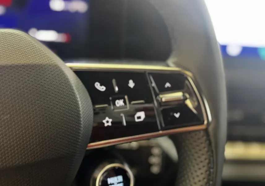 Gros plan sur les commandes multifonctions noires du volant de la Renault Clio gris clair, version techno TCe 115 ch.