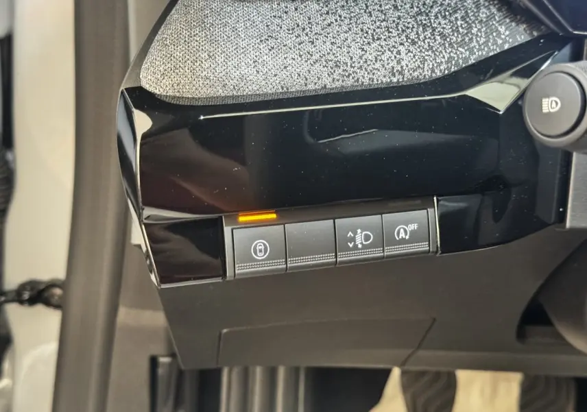 Gros plan sur les commandes noires du tableau de bord côté gauche de la Renault Clio Techno gris clair 2026.