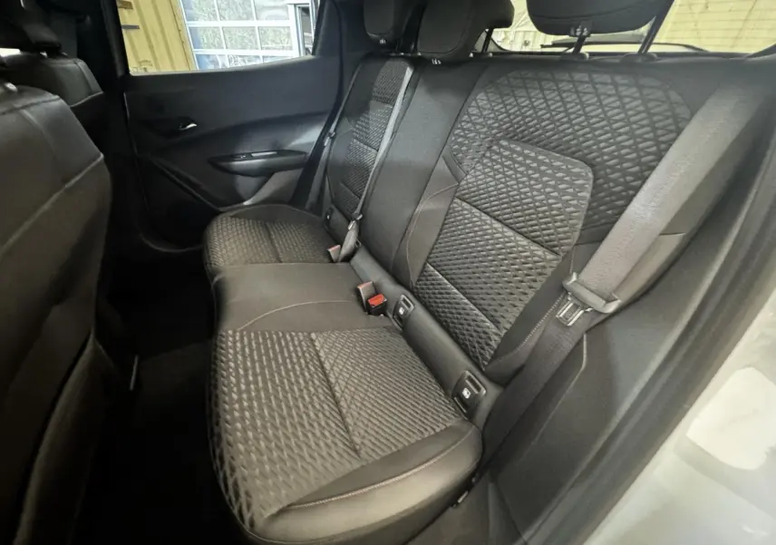 Vue intérieure arrière côté droit de la Renault Clio 2026, sièges tissu noir avec motifs géométriques.