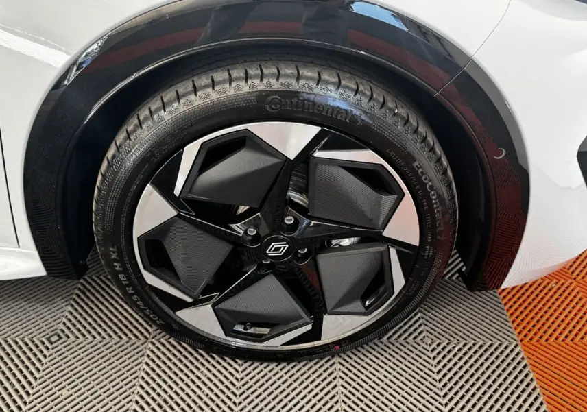 Gros plan sur la roue avant droite gris clair de la Renault Clio 2026 avec jante noire et argentée au design géométrique.