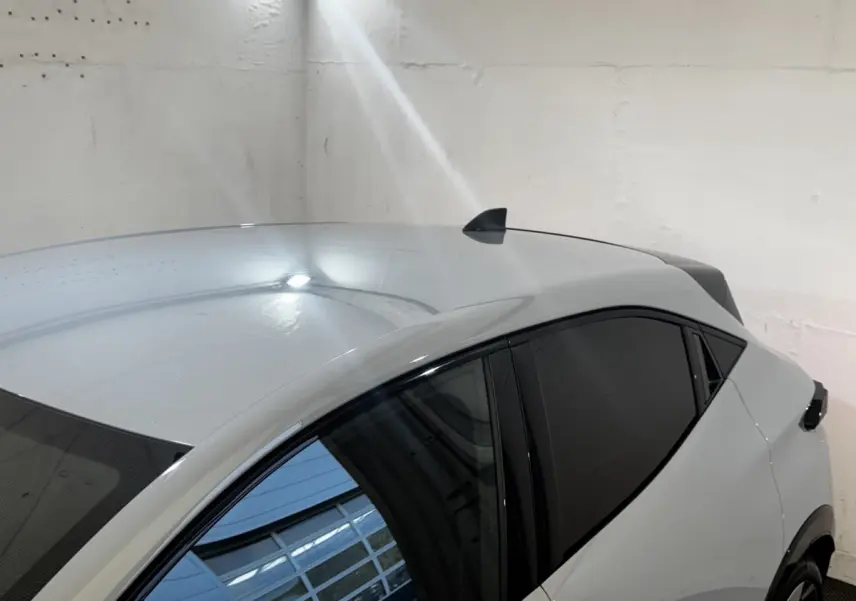 Vue de dessus côté droit d'une Renault Clio gris clair avec vitres teintées et antenne requin.