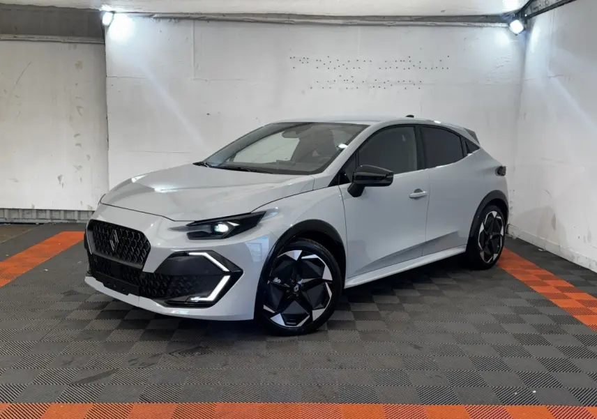 Renault Clio Techno TCe 115 gris clair vue 3/4 avant droit, avec jantes noires et phares LED allumés.