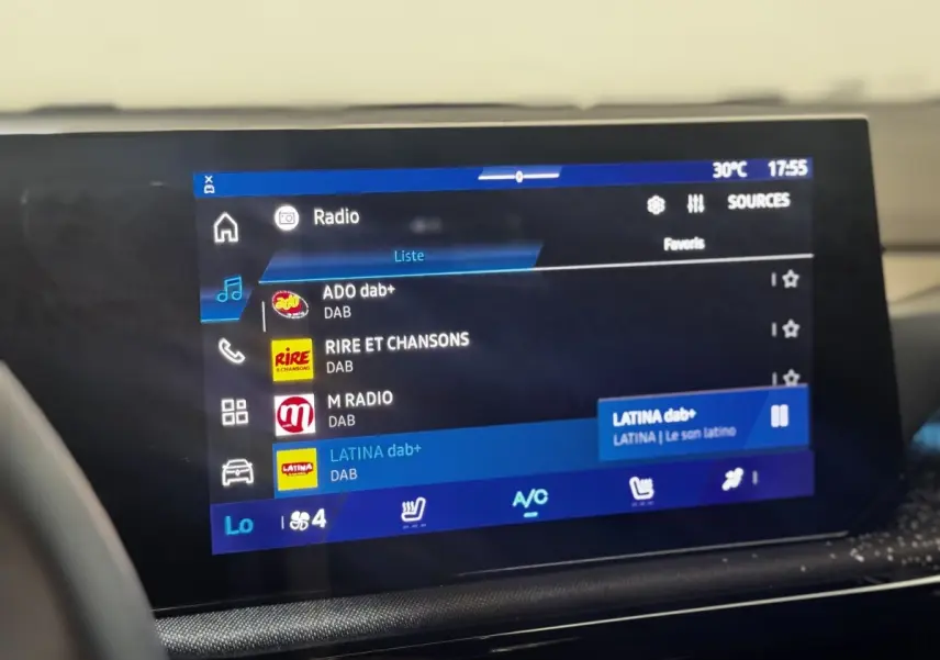Écran tactile central de la Renault Clio Techno TCe 115 2026 affichant les stations radio DAB, vue intérieure.