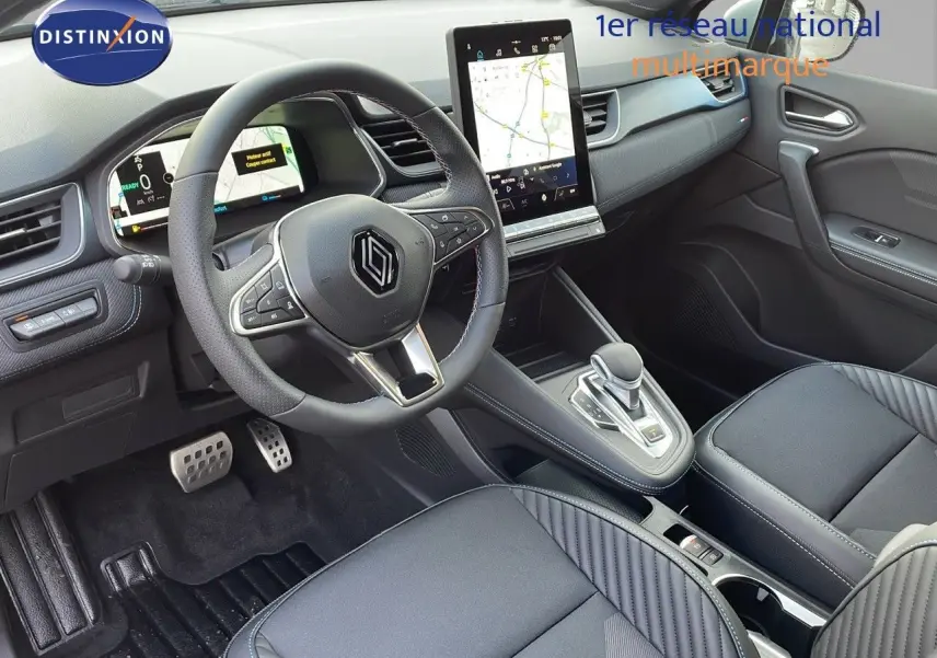 Intérieur avant du Renault Captur E-Tech hybride 2025, volant cuir noir, écran tactile vertical et console centrale moderne.