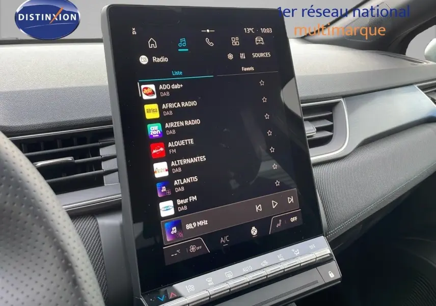 Écran tactile central affichant les stations radio dans l'habitacle moderne du Renault Captur noir étoile 2025.