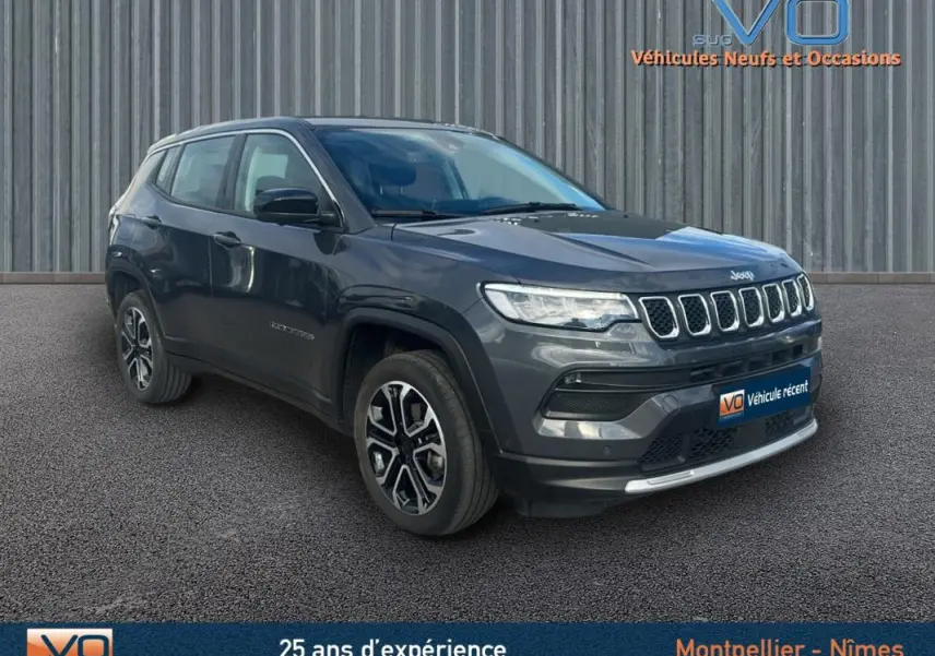 Jeep Compass gris 3/4 avant droit, SUV moderne avec calandre distinctive et jantes alliage bicolores.
