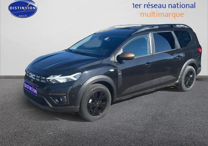 Dacia Jogger noir nacré en 3/4 avant droit, avec barres de toit et jantes alu noires brillantes.