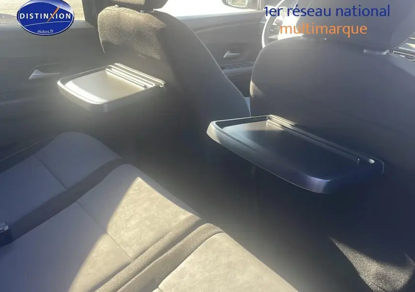 Vue intérieure arrière du Dacia Jogger 2024 avec tablettes rabattables sur les dossiers des sièges avant.