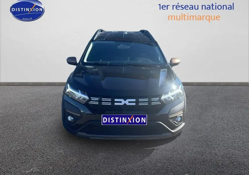 Vue frontale d'un Dacia Jogger 1.6 hybrid 140 noir nacré avec phares LED allumés sur fond neutre.