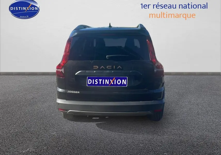 Vue arrière d'un Dacia Jogger noir nacré 2024 avec feux arrière verticaux et barres de toit visibles.