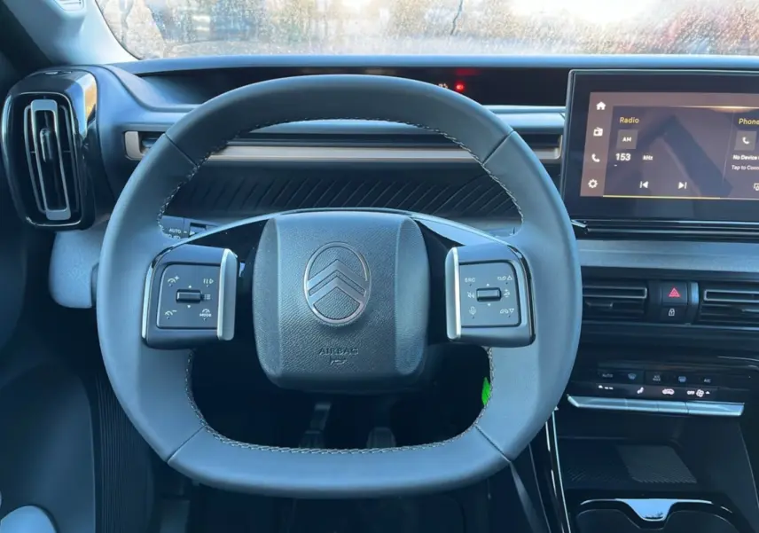 Vue rapprochée du volant cuir multifonctions et du tableau de bord numérique du Citroën C3 Aircross noir perla nera.