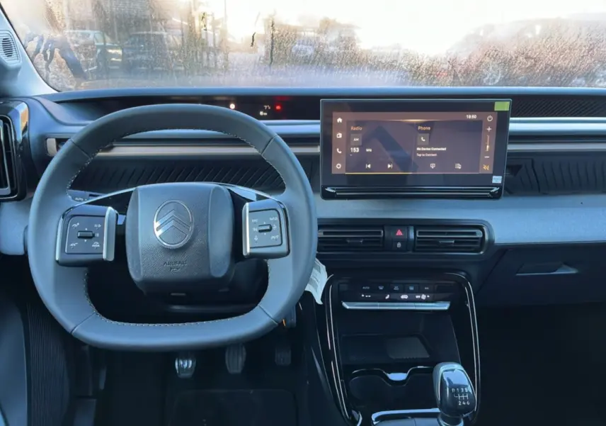Vue intérieure centrée sur le volant cuir multifonctions et l'écran tactile 10,25 pouces du Citroën C3 Aircross 2025.