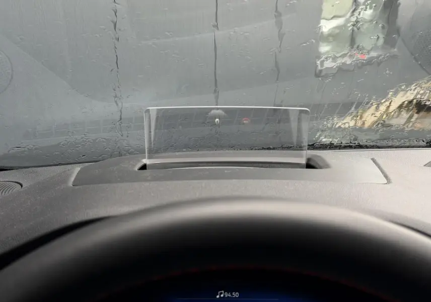 Vue intérieure du tableau de bord du Ford Kuga 2023 avec affichage tête haute et volant partiellement visible.