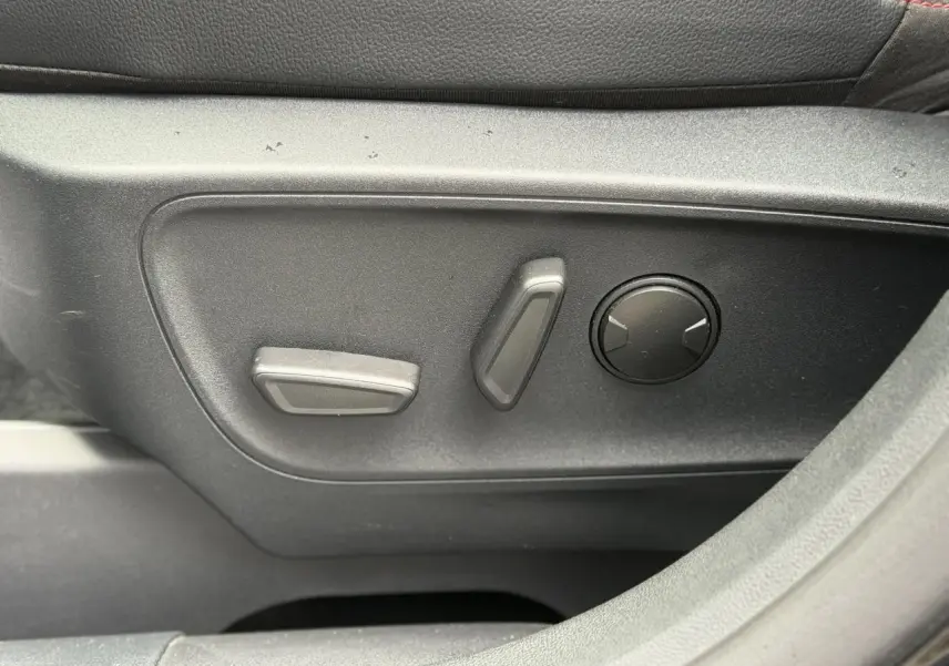 Gros plan sur les commandes de réglage électrique du siège conducteur du Ford Kuga noir Agathe 2023, finition ST-Line X.