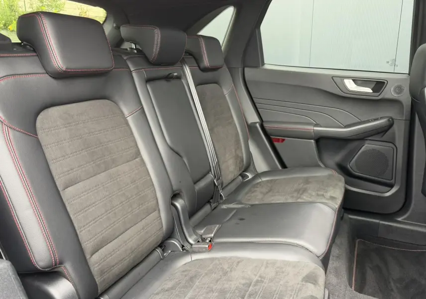 Vue latérale droite de la banquette arrière en cuir noir et alcantara avec surpiqûres rouges du Ford Kuga 2023.