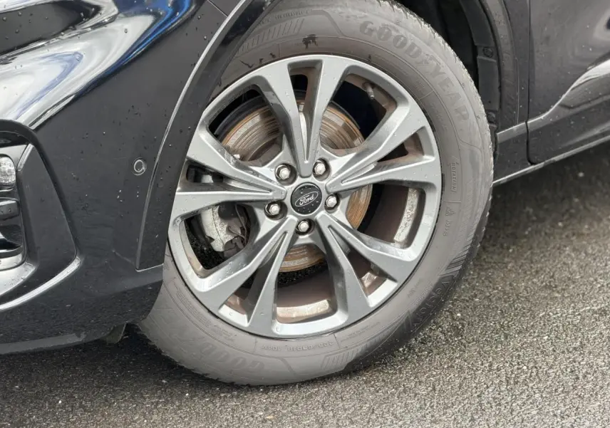 Gros plan sur la roue avant gauche du Ford Kuga noir Agathe avec jante alliage 18 pouces finition ST-Line.