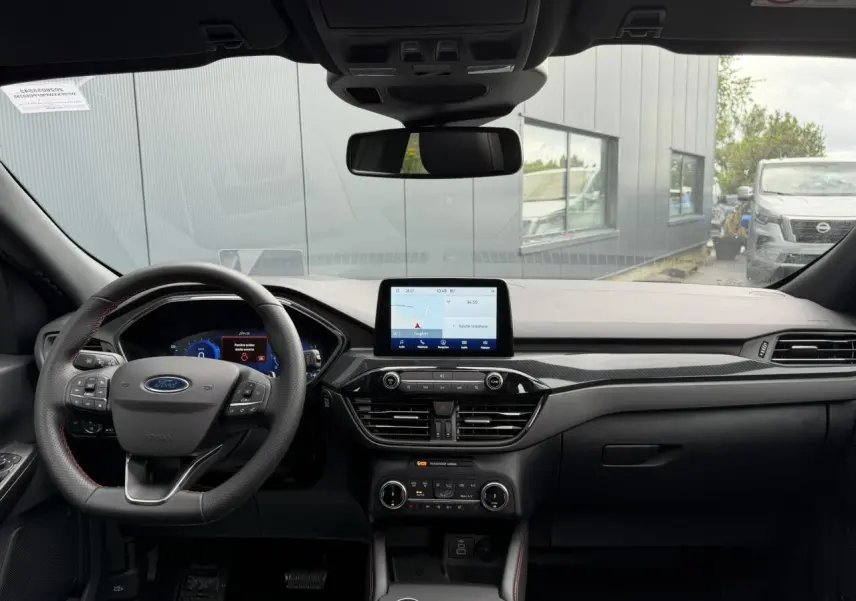 Vue frontale intérieure du Ford Kuga 2.0 EcoBlue 120 BVA ST-Line X 2023, tableau de bord noir avec écran tactile central.