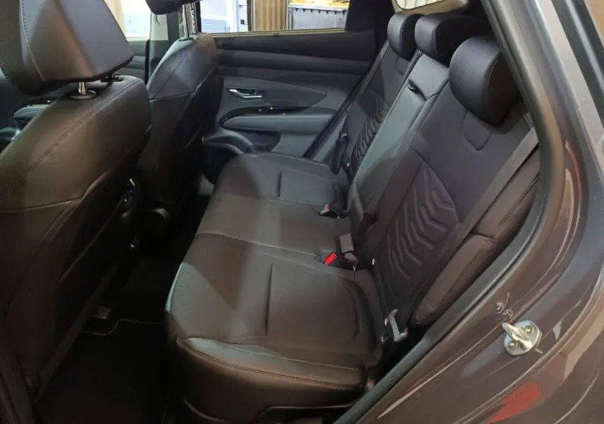 Vue côté droit de la banquette arrière en cuir noir du Hyundai Tucson 2025 gris foncé avec appuie-têtes intégrés.