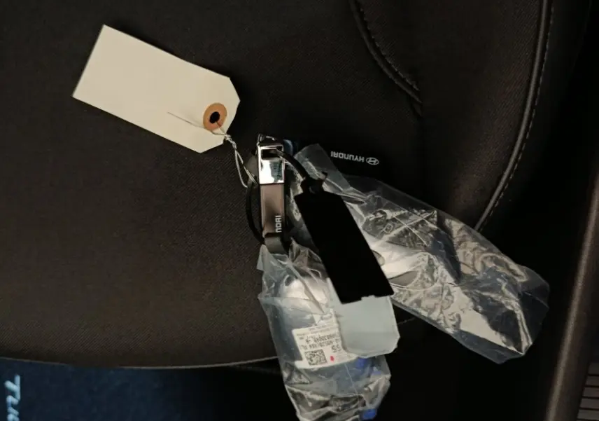 Gros plan sur la clé Hyundai posée sur un siège tissu noir à l'intérieur d'un Tucson gris foncé.