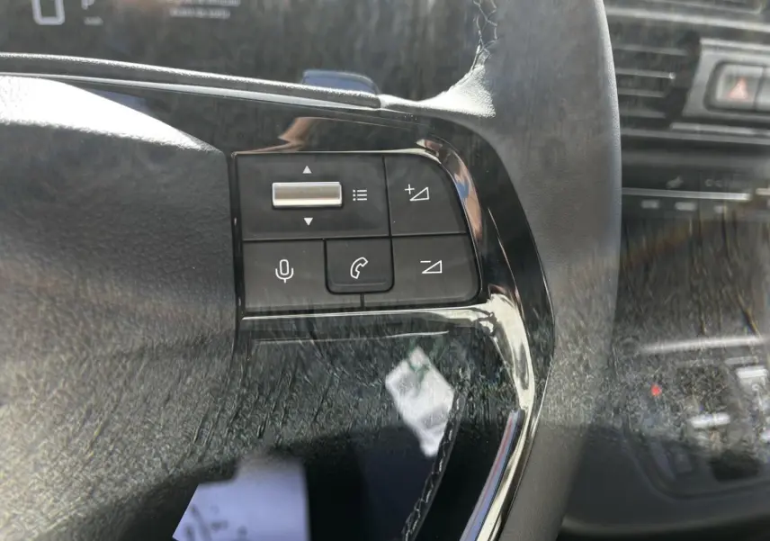 Gros plan sur les commandes du volant noir du Citroën Berlingo 2026, boutons de volume et appel visibles.