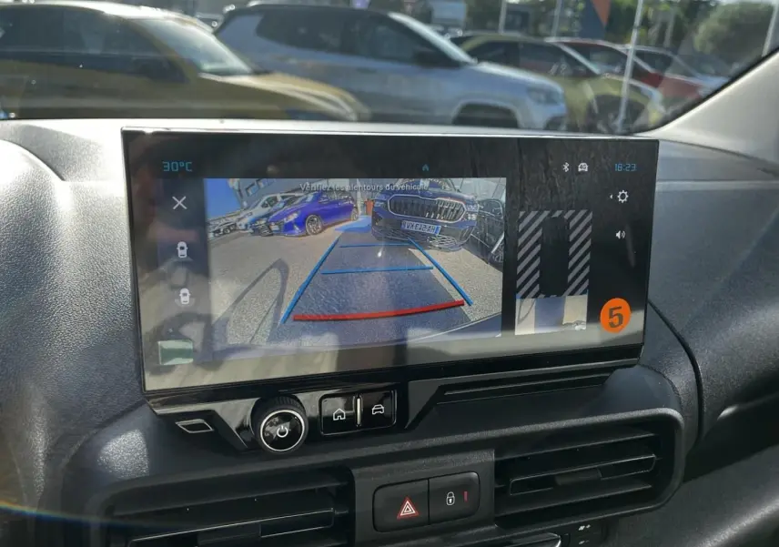 Écran intérieur du Citroën Berlingo noir, vue de la caméra de recul avec lignes de guidage colorées.