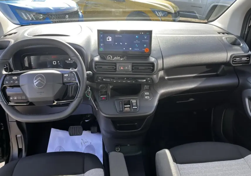 Vue intérieure frontale du tableau de bord noir et gris du Citroën Berlingo 2026 avec écran tactile et volant multifonction.