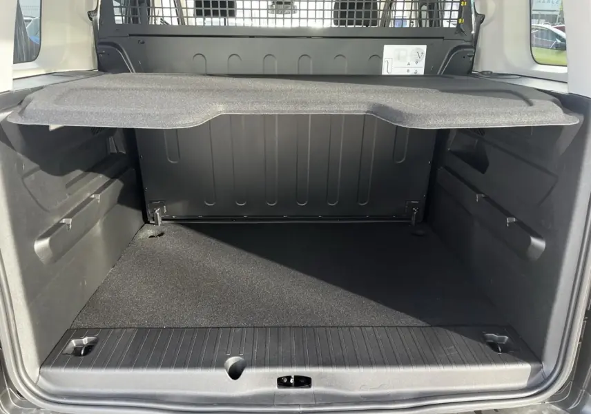 Vue arrière du coffre noir du Citroën Berlingo MPV N1 2026 avec séparation métallique et tablette de rangement.