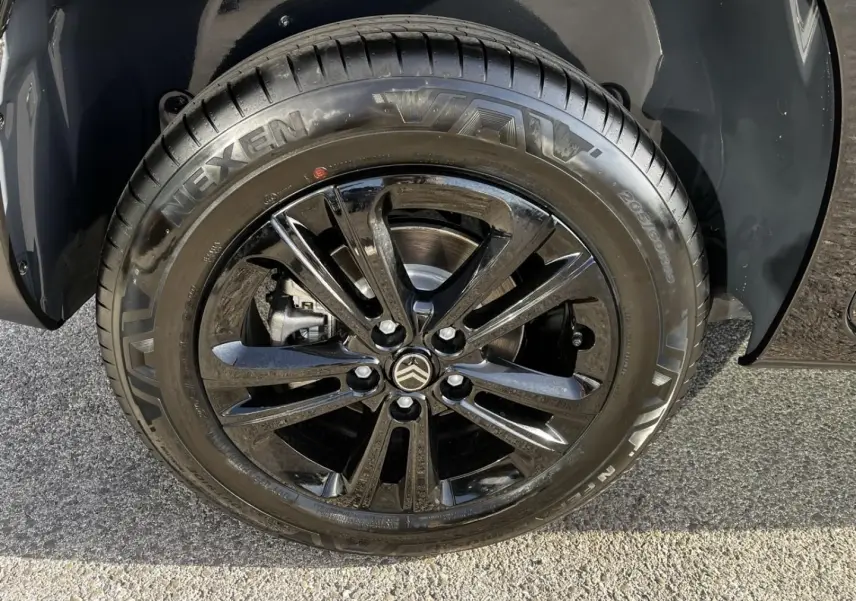 Gros plan sur la roue avant droite noire perla nera metal du Citroën Berlingo 2026 avec jante alliage noire brillante.