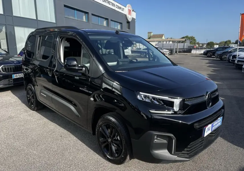 Vue 3/4 avant droite d’un Citroën Berlingo noir Perla Nera métallisé avec jantes noires et calandre moderne.