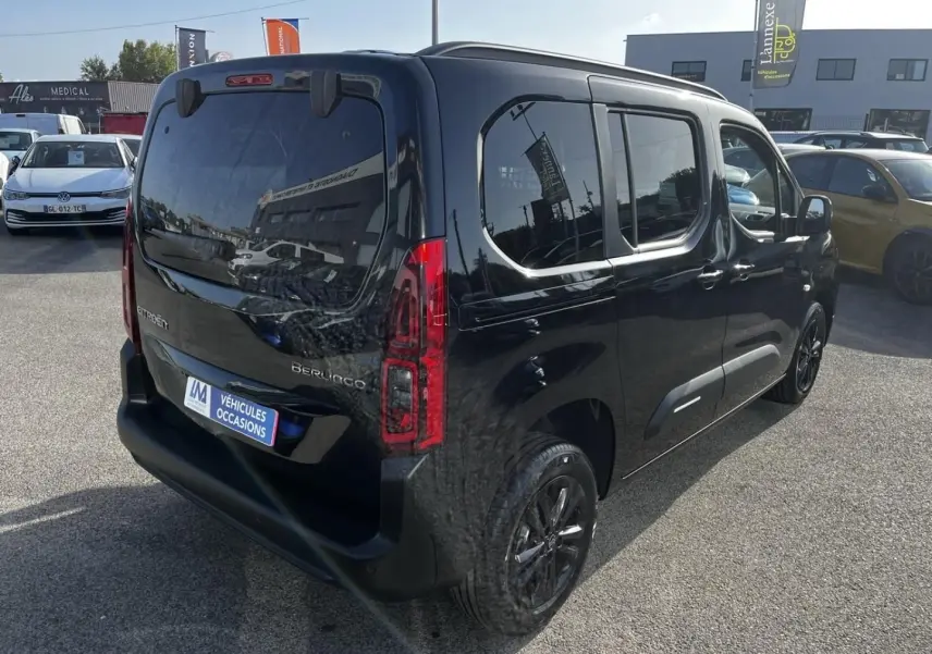 Vue 3/4 arrière droite d'un Citroën Berlingo noir Perla Nera métallisé avec vitres teintées et feux arrière LED.