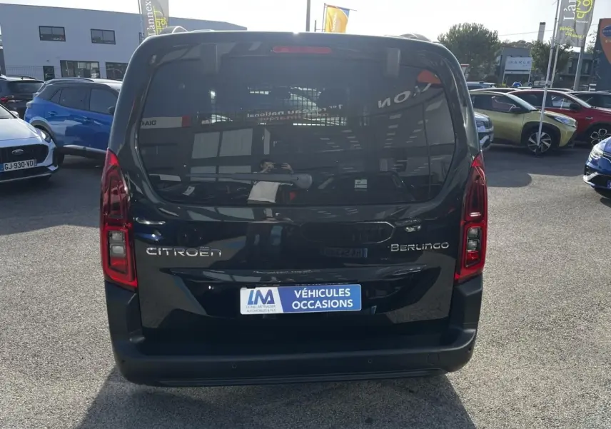 Vue arrière d'un Citroën Berlingo noir Perla Nera métallisé 2026, avec feux verticaux et plaque "Véhicules Occasions".