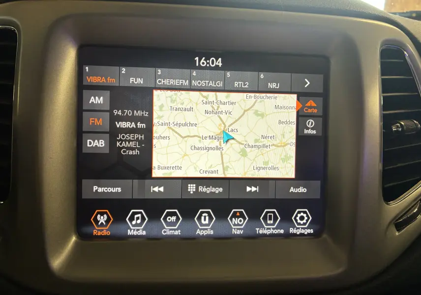 Écran tactile central du Jeep Compass Longitude 2021 montrant la navigation GPS et les options radio en intérieur noir.