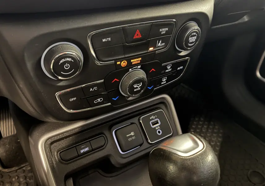 Gros plan sur la console centrale noire du Jeep Compass Longitude 2021 avec commandes climatisation et bouton sport.