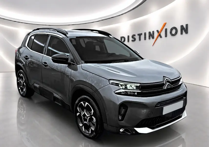 Citroën C5 Aircross gris 3/4 avant droit en showroom avec barres de toit et jantes alu distinctives.