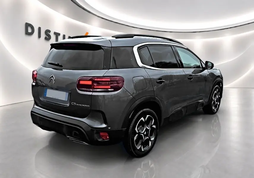 Vue 3/4 arrière droite d'un Citroën C5 Aircross gris avec vitres teintées et jantes alliage noires.