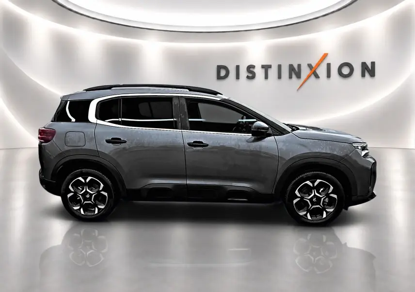 Vue de profil droit du Citroën C5 Aircross gris 2025 avec jantes alu et barres de toit noires.