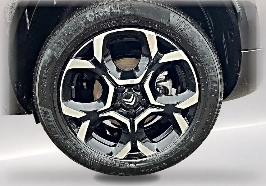 Gros plan sur la jante alu bicolore noire et argentée du Citroën C5 Aircross gris, avec logo Citroën au centre.