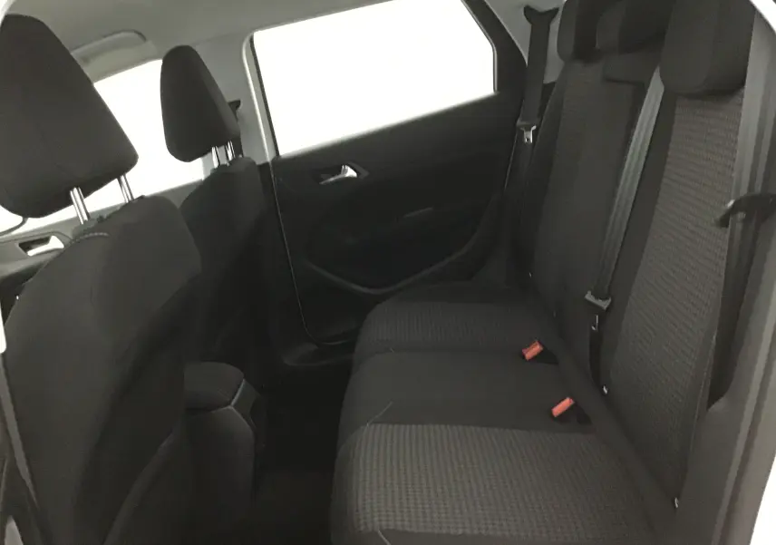 Vue intérieure côté droit des sièges arrière noirs à motifs de la Peugeot 308 SW 2018 blanche.