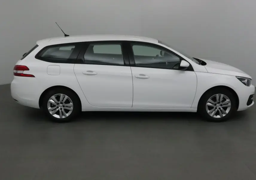Peugeot 308 SW blanche vue de profil côté gauche, break diesel 2018 avec jantes alliage 16 pouces.