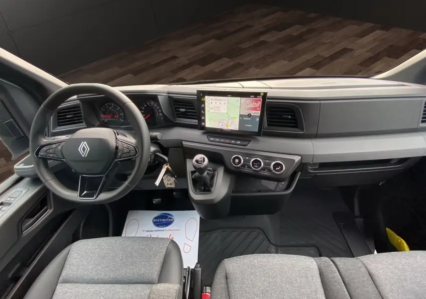Vue intérieure avant du Renault Master 2025, tableau de bord gris avec écran tactile et volant multifonction.