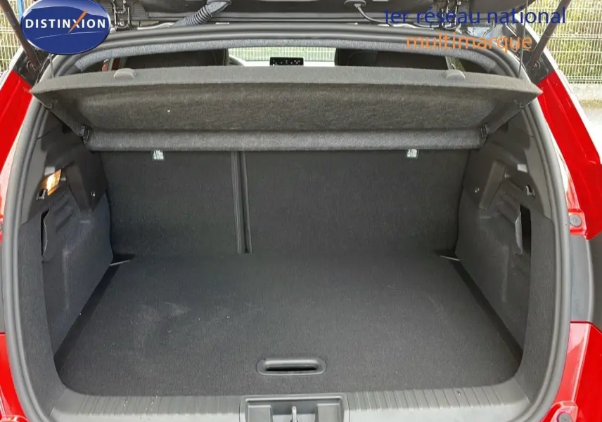 Coffre ouvert d’un Renault Captur rouge passion avec toit noir, vue arrière montrant l’espace de chargement vide.