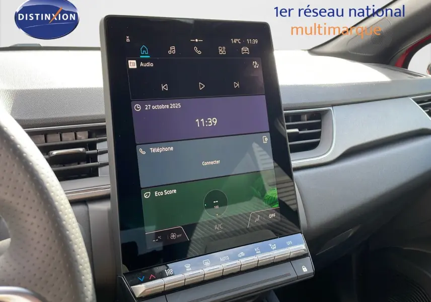 Écran tactile central en gros plan dans l’habitacle du Renault Captur E-Tech hybride 2025, volant partiel visible.