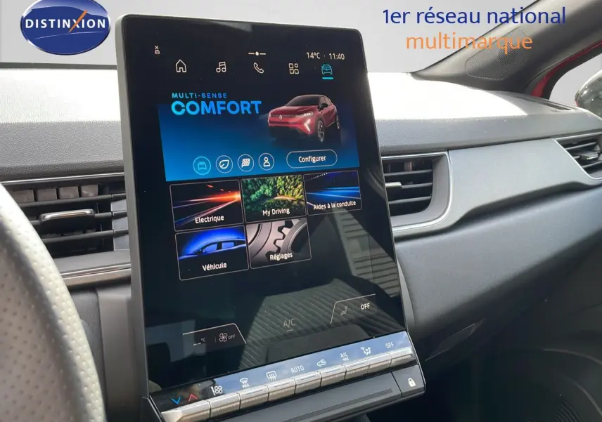 Écran tactile central du Renault Captur E-Tech hybride 2025, vue intérieure côté passager, tableau de bord gris.