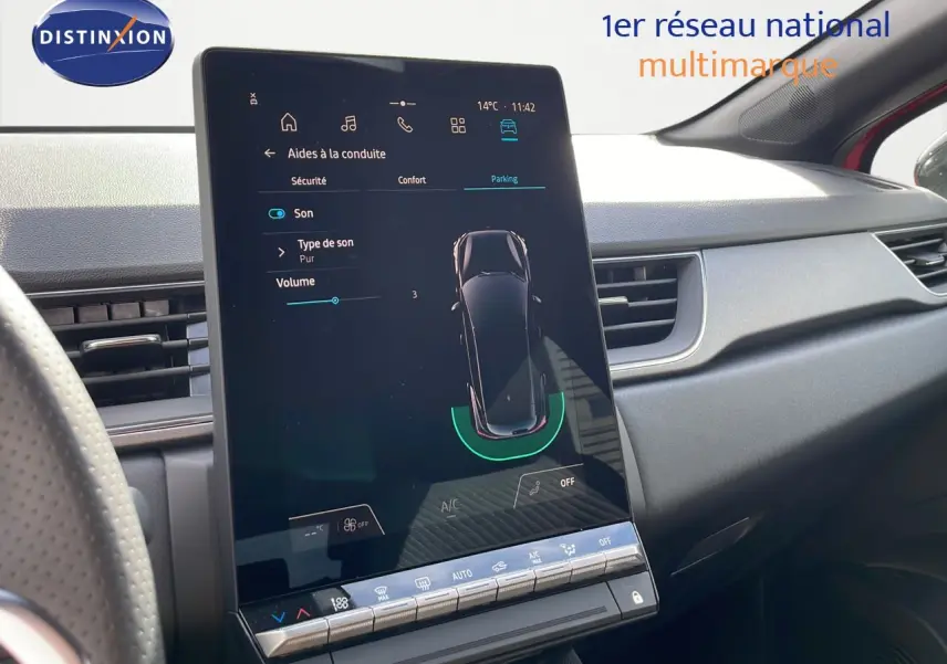 Écran tactile central du tableau de bord du Renault Captur rouge passion, affichant les aides à la conduite.