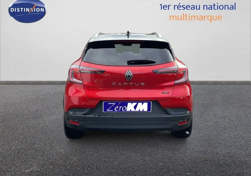 Vue arrière d'un Renault Captur rouge passion avec toit noir, version E-Tech hybride 2025, sur fond neutre.