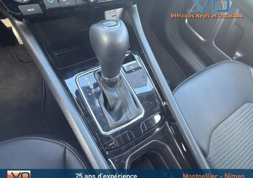 Gros plan sur la console centrale du Jeep Compass blanc 2024 montrant le levier de vitesse automatique et l'accoudoir.