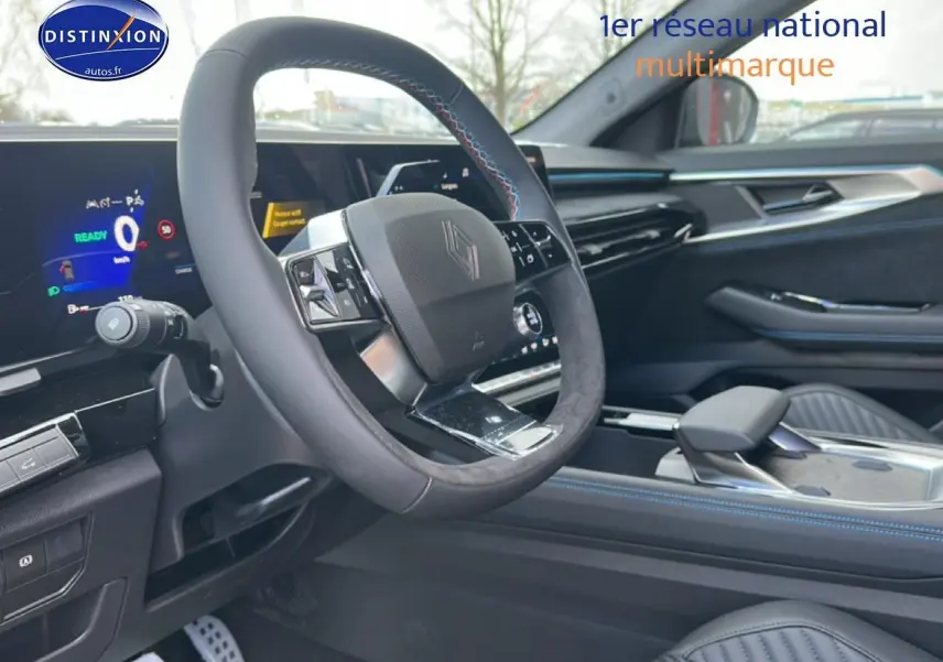 Vue intérieure côté conducteur du Renault Austral bleu, volant multifonction en alcantara avec surpiqûres bleues et écran tactile.