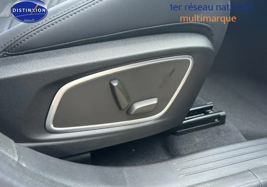 Gros plan sur les commandes électriques du siège avant côté droit d’un Renault Austral bleu esprit alpine.